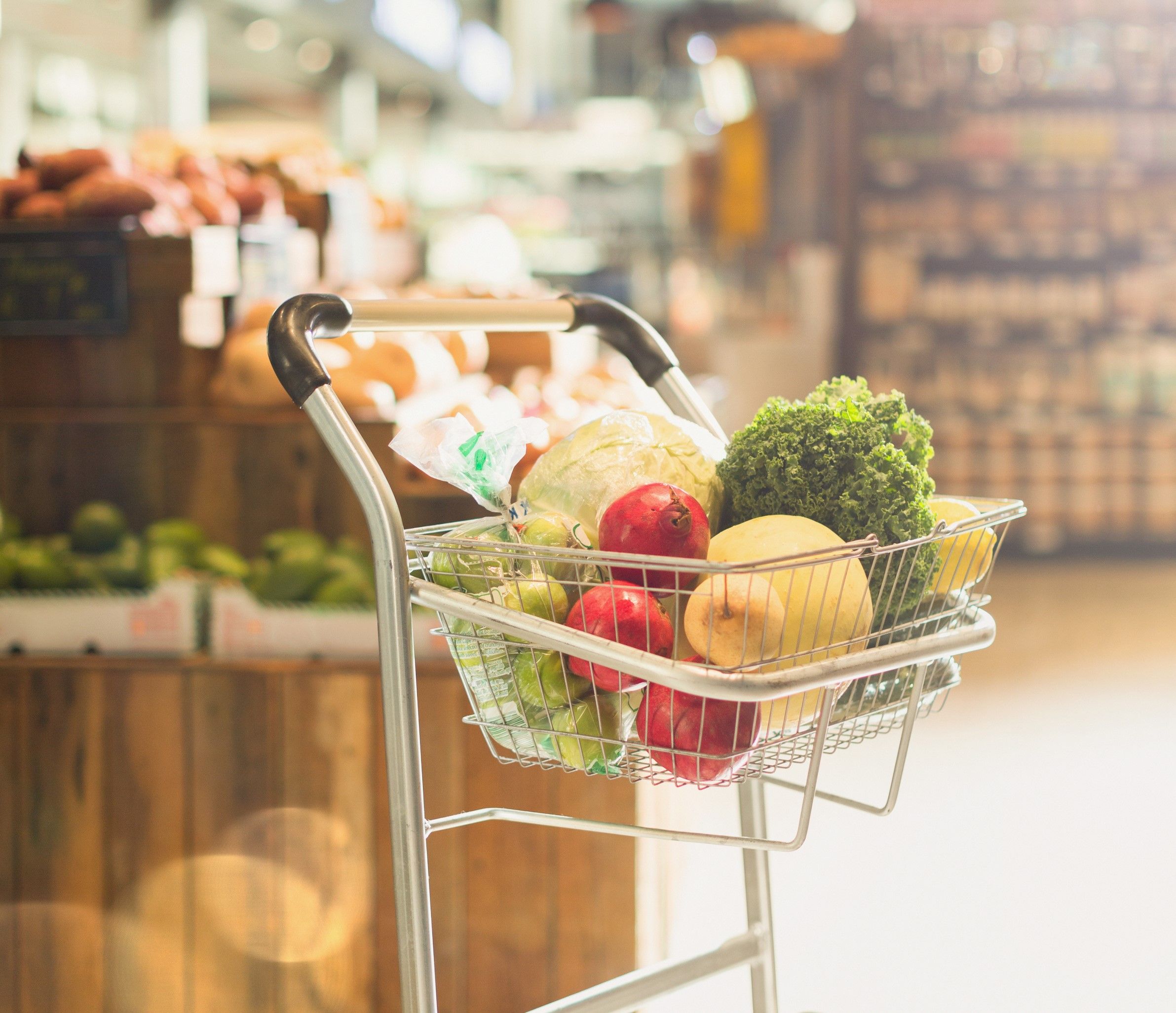 Produce and groceries in shopping cart in market